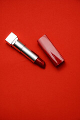 Stylish red lipstick on a red background top view. Place for text.