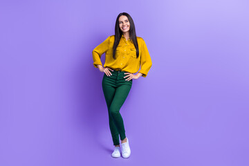 Fototapeta na wymiar Full size portrait of positive cheerful girl put arms waist look empty space advert isolated on purple color background