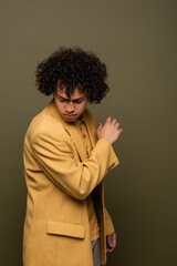 Fototapeta na wymiar young african american man in stylish yellow jacket posing on grey green background