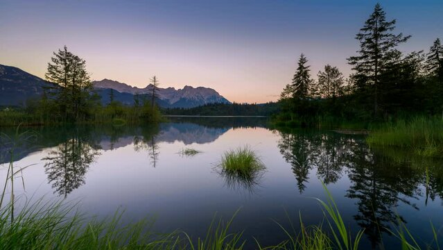 Day and night time lapse video at a gorgeous lake landscape in Bavaria, Germany, with the Milky Way and beautiful sunset and sunrise
