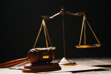 Justice and law concept.Male judge in a courtroom with the gavel, working with, computer and docking keyboard, eyeglasses, on table in morning light