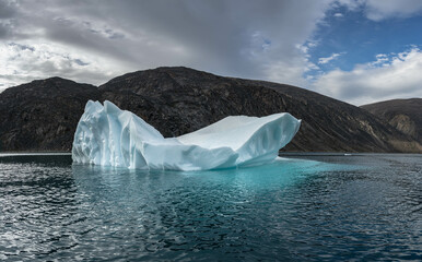 Big blue iceberg in water floats in the sea by Broughton Island, Nunavut, Canada.