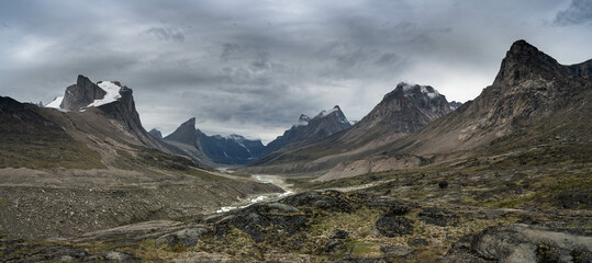 Arctic valley of Akshayuk Pass, Baffin Island, Canada on a cloudy day. Dramatic arctic landscape with Mt. Breidablik and Mt. Thor. © Mariana Ianovska