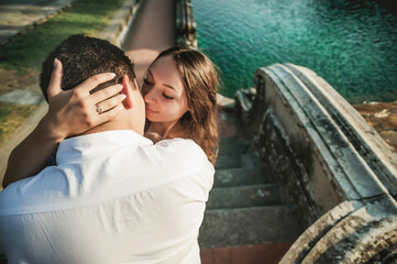 A young couple is hugging in the hall of a large historic building. Tender relations between a man and a woman. A walk in historical places. Good weather for a walk. Meeting and excursion.
