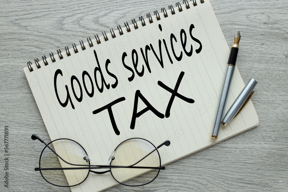 Poster finance concept with stack of coins, gst or good and services tax. open notepad with text. pen and g