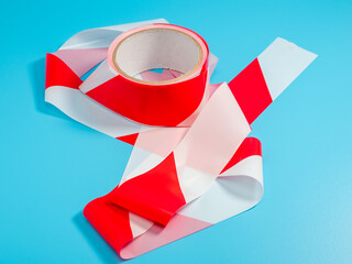 Roll of barrier tape on a blue background. Close-up.