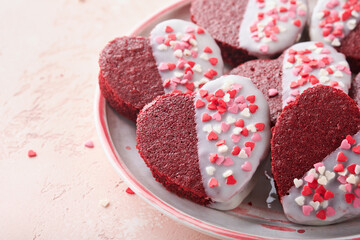 Red velvet or brownie cookies on heart shaped in chocolate icing on a pink romantic background. Dessert idea for Valentines Day, Mothers or Womens Day. Tasty homemade dessert. Cake for Valentines Day