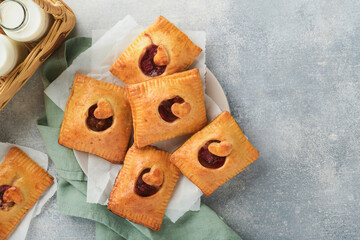 Valentines day heart shaped Hand pies. Mini puff pastry or hand pies stuffed with apple and sprinkle sugar powder in plate. Idea for homemade romantic snack Valentines day. Top view. Copy space.