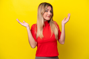 Young Uruguayan woman isolated on yellow background making doubts gesture