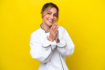Uruguayan chef woman isolated on yellow background applauding after presentation in a conference