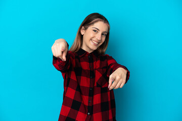 Fototapeta premium Young caucasian woman isolated on blue background pointing front with happy expression