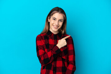 Fototapeta premium Young caucasian woman isolated on blue background pointing to the side to present a product