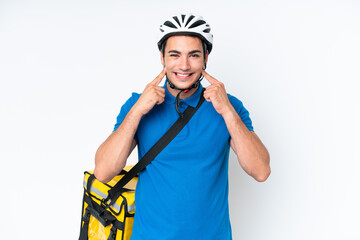 Young caucasian man with thermal backpack isolated on white background smiling with a happy and pleasant expression