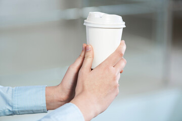 close-up of women's hands with a cup of coffee