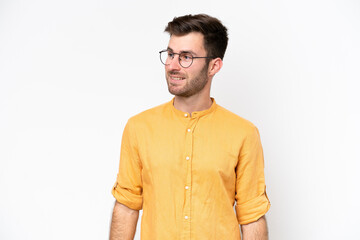 Fototapeta premium Young caucasian man isolated on white background looking to the side and smiling