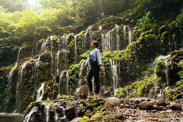 Inspired woman standing on cliff in forest