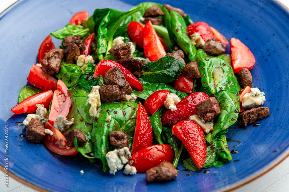 Wall mural Salad with fried duck liver, brie cheese, strawberries, tomatoes and spinach leaves