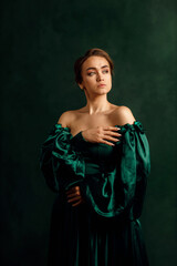 waist portrait of a girl in a green dress standing against a green wall