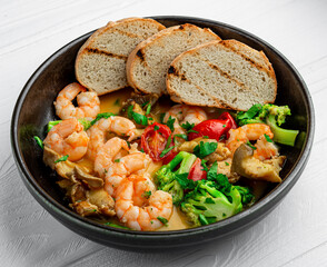 Shrimps in a creamy sauce with mushrooms, broccoli and various vegetables