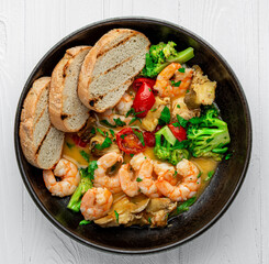 Shrimps in a creamy sauce with mushrooms, broccoli and various vegetables
