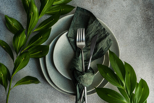 Overhead view of a place setting with ruscus branches
