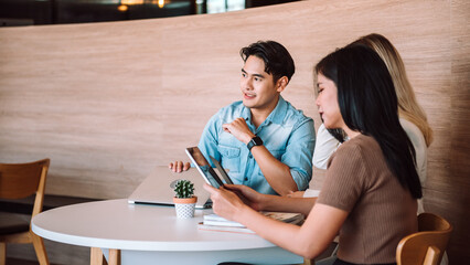 Group of young adult people using laptop and discussing about work at co-working space