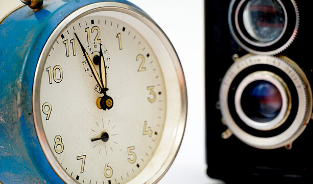 retro alarm clock and vintage film camera on white background, time and vintage theme