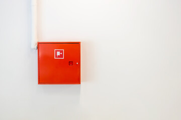 Red fire cabinet with hydrant, on a white wall, security system
