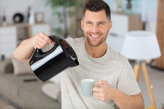 man pouring water from electric kettle