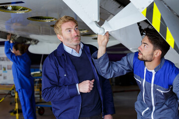 two men working under an airplane