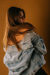 A close up photo of a girl with long hair and blue texas jacket looking aside