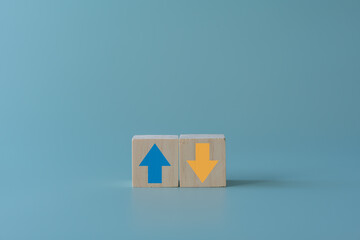 Wooden block with up and down arrow concept of differentiation or Opposite direction. Blue arrow up...