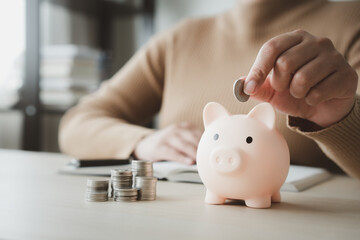 Woman save money for household expenses in piggy bank