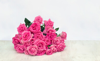 Bouquet pink flowers roses on a white wooden table on light background with space for text