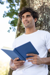 young relaxed man reading book in nature