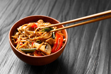 Buckwheat noodles with vegetables and chicken meat on a dark background.