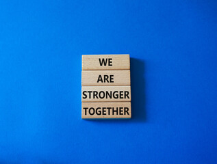 We are stronger together symbol. Wooden blocks with words We are stronger together. Beautiful blue background. We are stronger together concept. Copy space.
