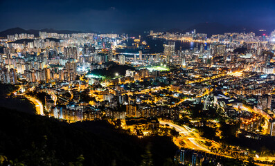 Fototapeta premium Panorama aerial view of Hong Kong Kowloon's crowded buildings and Victoria Harbour in China.