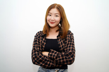 Fototapeta premium Portrait of a confident smiling girl standing with arms folded and looking at the camera isolated over white background.