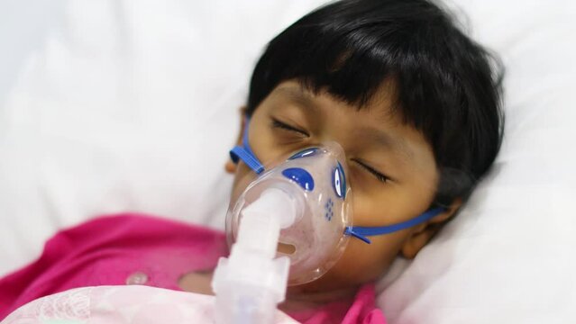 Sick boy inhalation therapy by the mask of inhaler. Baby has asthma and need nebulizations. Patient Boy use inhalation with Nebulizer mask at hospital. The baby are spraying bronchodilators .