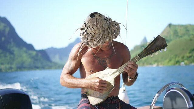 Traditional Polynesian man playing ukulele music on cultural tour in Bora Bora, Tahiti. French Polynesia. Exotic travel vacation getaway, romantic honeymoon destination.