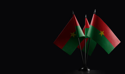 Small national flags of the Burkina Faso on a black background