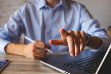 Businessman touching the screen with a stylus in hand. For business illustration floating screen mockup. Typing in the air and pointing towards the camera