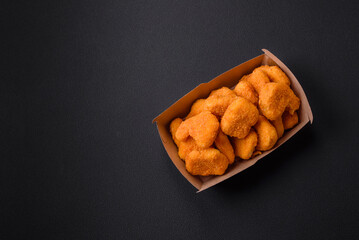 Delicious fresh crispy chicken nuggets on a dark concrete background