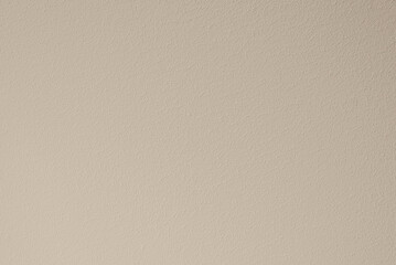 The texture of the wall painted with beige paint. Textured beige background