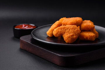 Delicious fresh crispy chicken nuggets on a dark concrete background