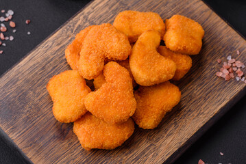 Delicious fresh crispy chicken nuggets on a dark concrete background
