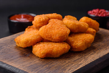 Delicious fresh crispy chicken nuggets on a dark concrete background