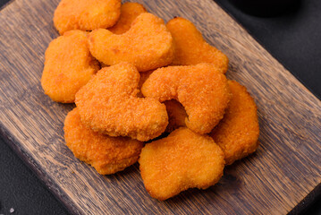 Delicious fresh crispy chicken nuggets on a dark concrete background