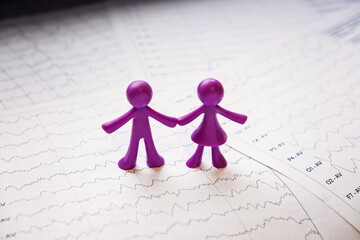 International Epilepsy Day, Epilepsy awareness. Purple two toy people on brain wave on electroencephalogram EEG for epilepsy